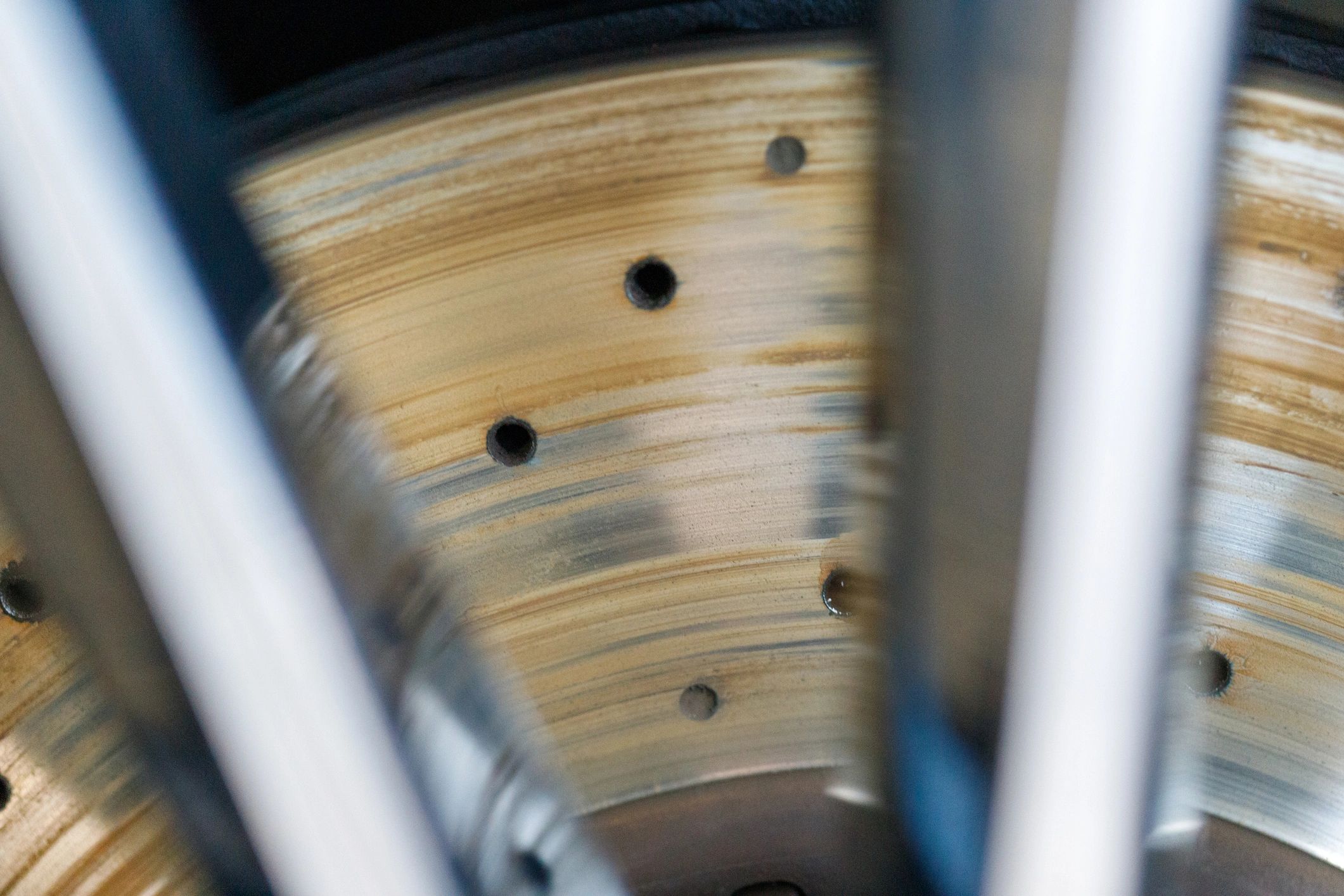 Detailed view of a drilled brake rotor on a performance vehicle